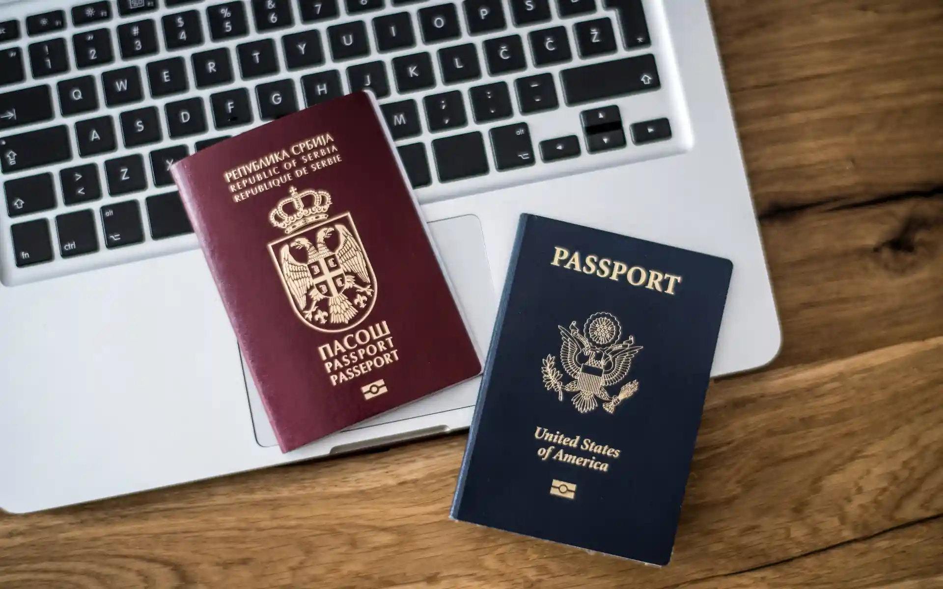Serbian and US passports on a laptop
